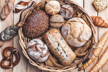 A basket full of delicious fresh bread on wooden background