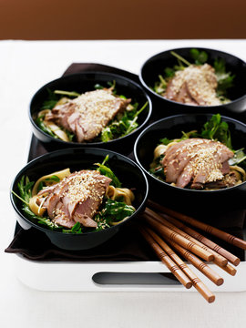 Bowls of pork fillets with noodle salad