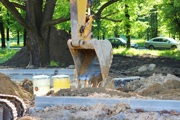 Excavator digs to plastic tank gas oil catcher in the ground during the construction of a car park for tourist buses, Russia.