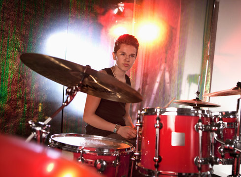 Teenage boy playing drum kit