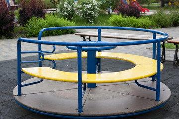 Small blue children's carousel in the yard