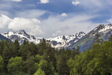 Fototapeta na wymiar Горный пейзаж, красивый вид на живописные горные склоны, панорама горного ущелья, белые облака на небе, дикая природа и горы Северного Кавказа
