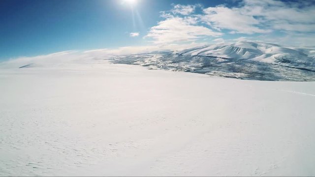 Man skier skiing down mountain with friends and then they wait 
