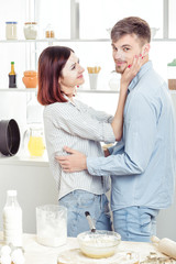 happy Couple in love cooking dough in kitchen