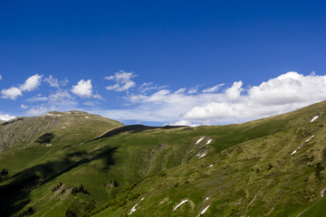 Fototapeta premium Горный пейзаж, красивый вид на живописные горные склоны, панорама горного ущелья, белые облака на небе, дикая природа и горы Северного Кавказа