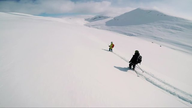 Man skier skiing slowly down mountain with friends - sunny day - pov
