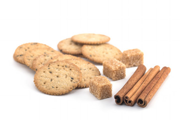 Biscuits, cane sugar, cinnamon sticks on white background