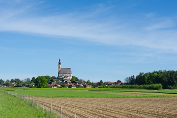 Idyllic and pastoral landscape in Bavarian township Anger with old church