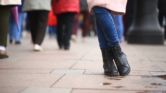 The feet of a man who wants to go to the toilet in the midst of a crowded street