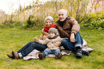 Naklejka na ściany i meble Happy family in autumn Park. Family values. The link between generations. 