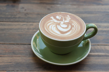 Cup of hot coffee latte with beautiful style on wood table