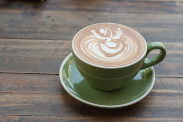 Cup of hot coffee latte with beautiful style on wood table