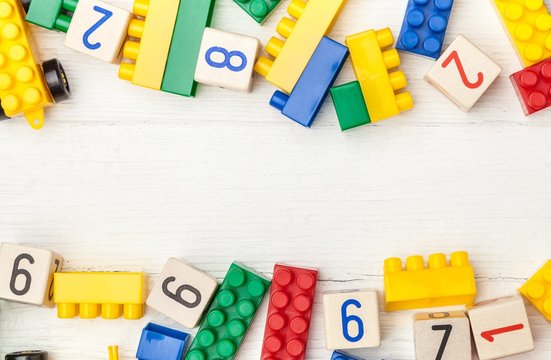 Wooden cubes with numbers and colorful toy bricks.