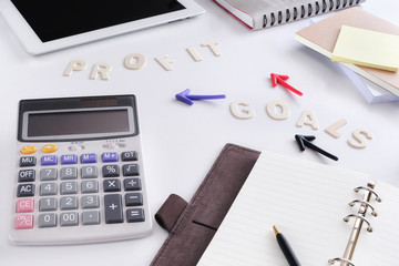 Words of goals and profit with arrow on working desk, business challenge concept and planning idea