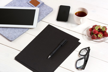 Modern workplace with digital tablet computer and mobile phone, cup of coffee, pen and empty sheet of paper.