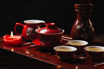 Traditional red chinese tea set, red porcelain with traditioanl chinese theatre masks