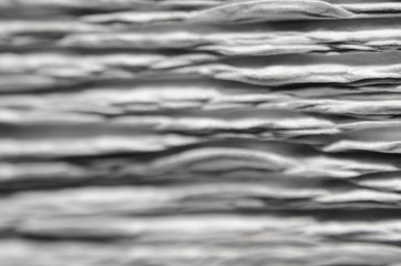 Obraz premium White texture of embossed paper. Macro. Shallow depth of field. Abstract background with deep grooves in the texture of corrugated paper. Pattern of horizontal grooves