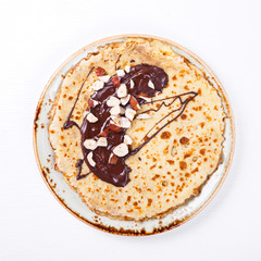 Thin Pancakes with Honey,Chocolate,Hazelnut on a White Background.Tradition,Holiday,Dessert,Breakfast,Pastries.Copy space for Text. selective focus.