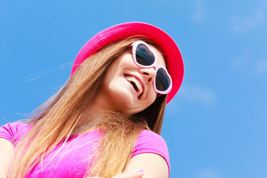Woman wearing heart shaped sunglasses and hat