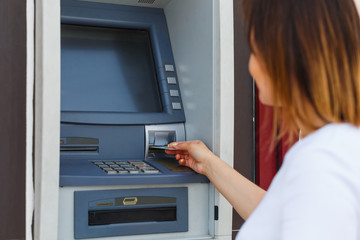 Young beautiful woman using an ATM