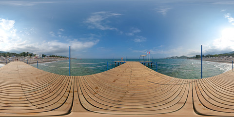 View from a wooden pier on the sea and beach, mountains, sky. 360 degree spherical panorama from...