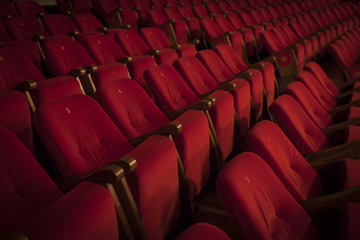 Empty red armchairs of a theater