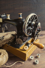 Old antique sewing machine, thread, glasses Concept of manual labor, hobbies and history