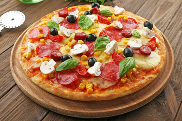 Freshly baked pizza on wooden background