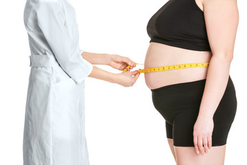 Doctor measuring stout adult woman on white background. Weight loss concept