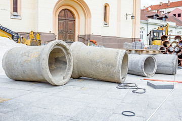 Concrete drainage pipes are on a construction site ready to be placed in