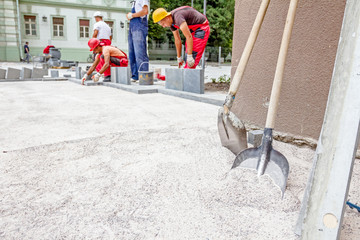 Masons are fitting flagstone, teamwork