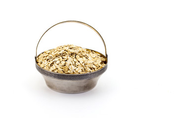 a silver bowl of uncooked rolled oats isolated on white background