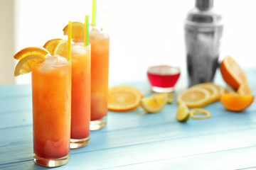 Glasses of Tequila Sunrise cocktail with citrus slices on table
