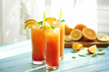 Glasses of Tequila Sunrise cocktail with citrus slices on table