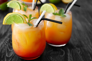 Glasses of Tequila Sunrise cocktail on wooden table