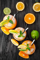 Glasses of Tequila Sunrise cocktail with citrus slices on wooden table