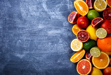 Different Citrus Fruit on a Blue Background .Mixed Colorful Tropical Background.Food or Healthy diet concept.Vegetarian.Toned image.Copy space for Text. selective focus.