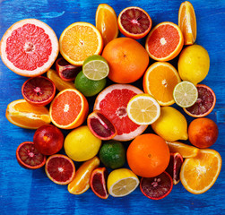 Different Citrus Fruit on a Blue Background .Mixed Colorful Tropical Background.Food or Healthy diet concept.Vegetarian.Copy space for Text. selective focus.