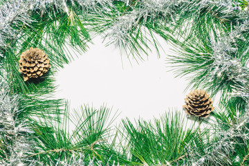 Christmas background with silver decoration, pinecones and green pine leaves. Copy space for text