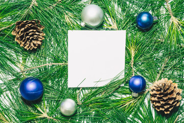Obraz na płótnie Canvas X-mas background with christmas balls, pinecones and green pine leaves. Square copy space for text