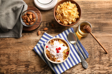 Delicious muesli with berries and yogurt on wooden table