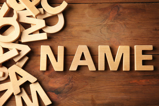 Word NAME on wooden background. Concept of choosing baby name