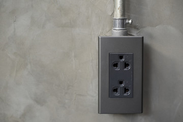 Electricity plug on industrial concrete wall background
