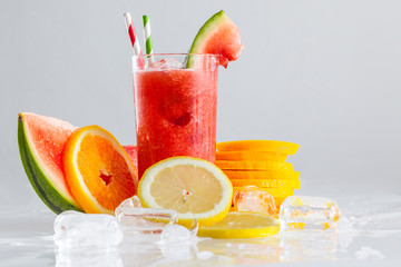 frisch gepresster Saft im Glas mit geschnittenen Zitrusfrüchten und Eiswürfeln garniert