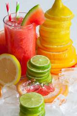 frisch gepresster Saft im Glas mit geschnittenen Zitrusfrüchten und Eiswürfeln garniert