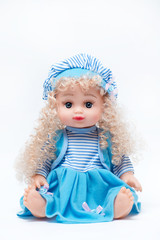 Beautiful baby doll with blond hair in blue dress isolated on white background