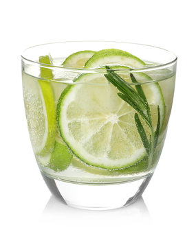 Glass of tasty lemonade with lime slices and rosemary on white background