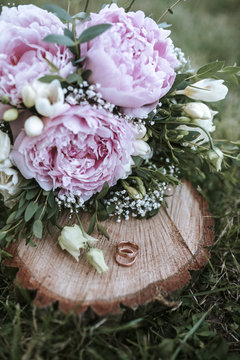 wedding rings on wood with flowers