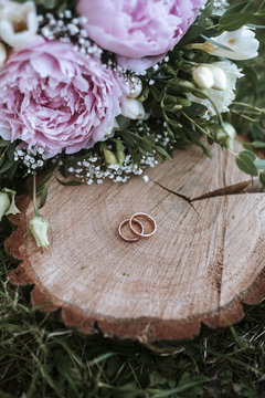 wedding rings on wood with flowers