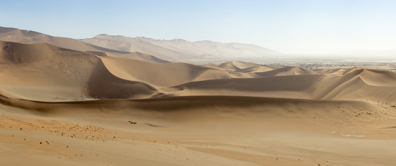 Panoramic view of sand-dunes in the Sossusvlei Nature Reserve in Namibia.  These reddish dunes at the main "vlei" (salt pan) are massive, and attract many tourists.